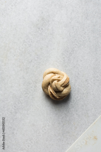 Swedish cinnamon buns dough on a white marble table, unbaked cinnamon twists, process of making Kanelbullar