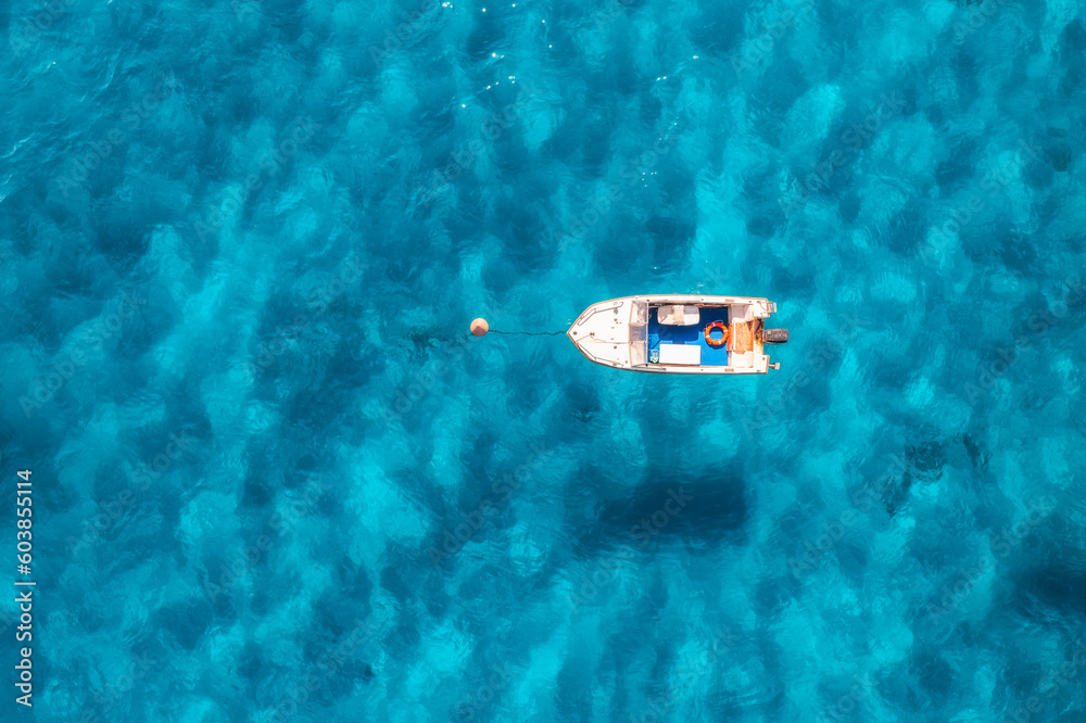 Aerial view of beautiful little boat in blue sea at sunset Aerial view of beautiful little boat in blue sea at sunset