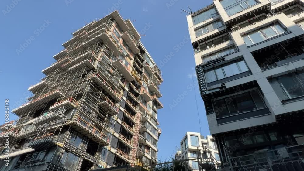 Modern futuristic high-rise residential buildings under construction. Bottom up view. Extreme wide angle Modern futuristic high-rise residential buildings under construction. Bottom up view. Extreme wide angle