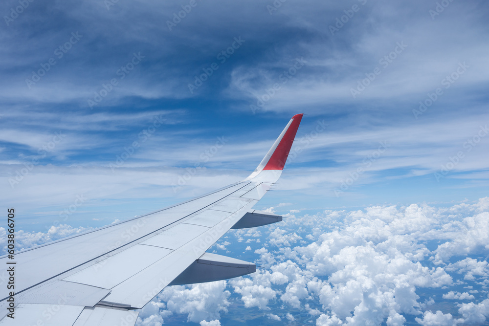 Airplane wing flying above the sky with white clouds. View from aircraft window. flying and traveling concept. Airplane wing flying above the sky with white clouds. View from aircraft window. flying and traveling concept.