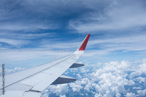 Airplane wing flying above the sky with white clouds. View from aircraft window. flying and traveling concept.