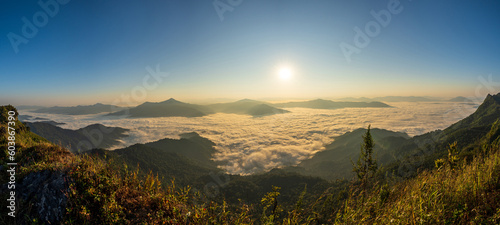 Beautiful landscape on the mountains at sunrise. Spectacular view in foggy valley covered forest under morning sky.