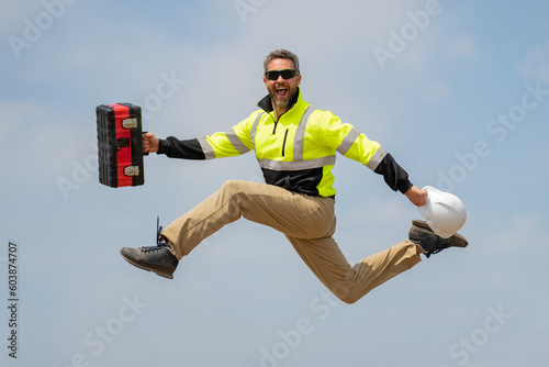 Fast building. Funny construction worker jumping. Excited jump of builders in helmet. Worker in hardhat. Construction engineer in builder uniform jump. Excited foreman jump. Speed build. photo