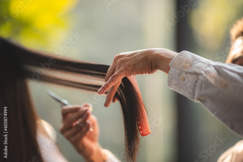 Asian Hairdresser giving treatment and barber occupation service, Professional hairstylist combing and using scissors cut woman's hair to young beautiful customer girl in beauty salon