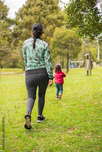 walking a mother with her daughter, lifestyle on rest day in the park surrounded by nature, love of family having fun outside, they wear sportswear