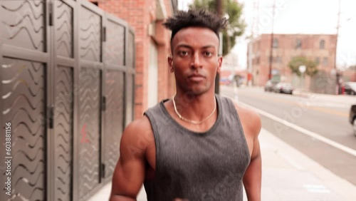 Athletic African American man with a  deformed left hand jogging on the street in downtown Los Angeles.