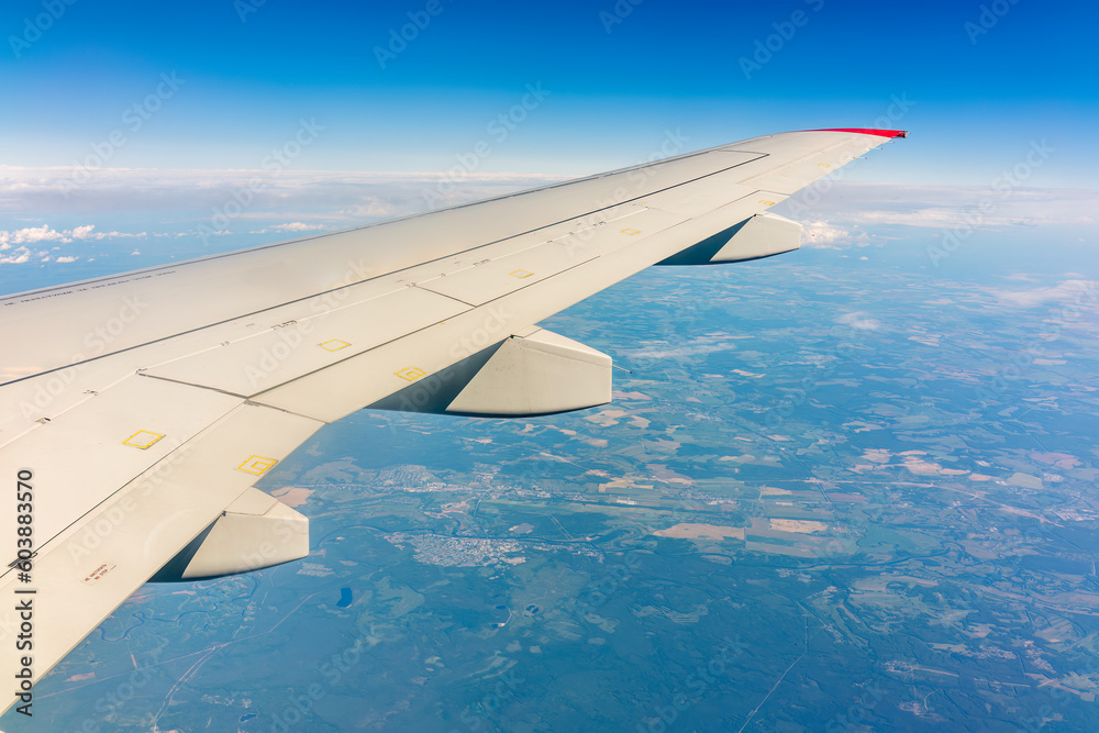 View from the airplane window at a beautiful cloudy sky and the airplane wing View from the airplane window at a beautiful cloudy sky and the airplane wing