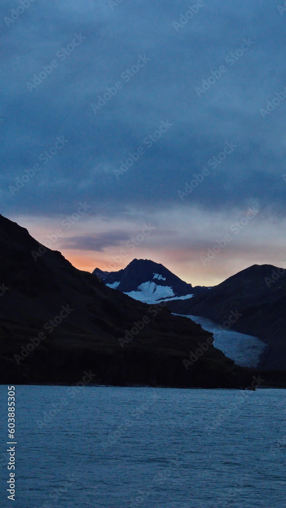Sunset over mountains with a glacier at Fortuna Bay, South Georgia Island