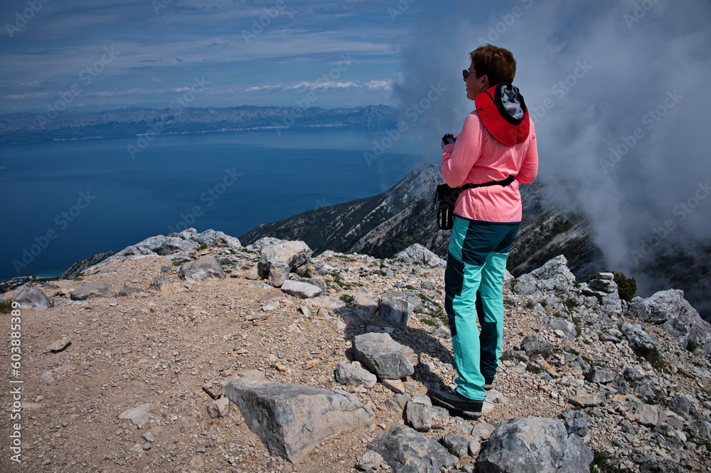Rear view of senior woman hiking in rocky landscape in Croatia