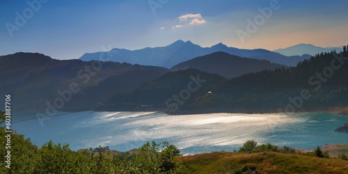 lake of Roselend and blue turquoise water borded by range mountains at sunset in french Alps.