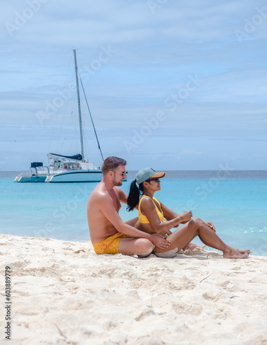 a couple of men and women on a boat trip to Small Curacao Island with a white beach and turqouse colored ocean