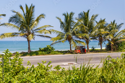 Tuk tuk left on the road by the Pacific Ocean in Sri Lanka