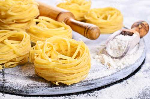 Tagliatelle yellow in dry form in the form of a slot on a floured surface