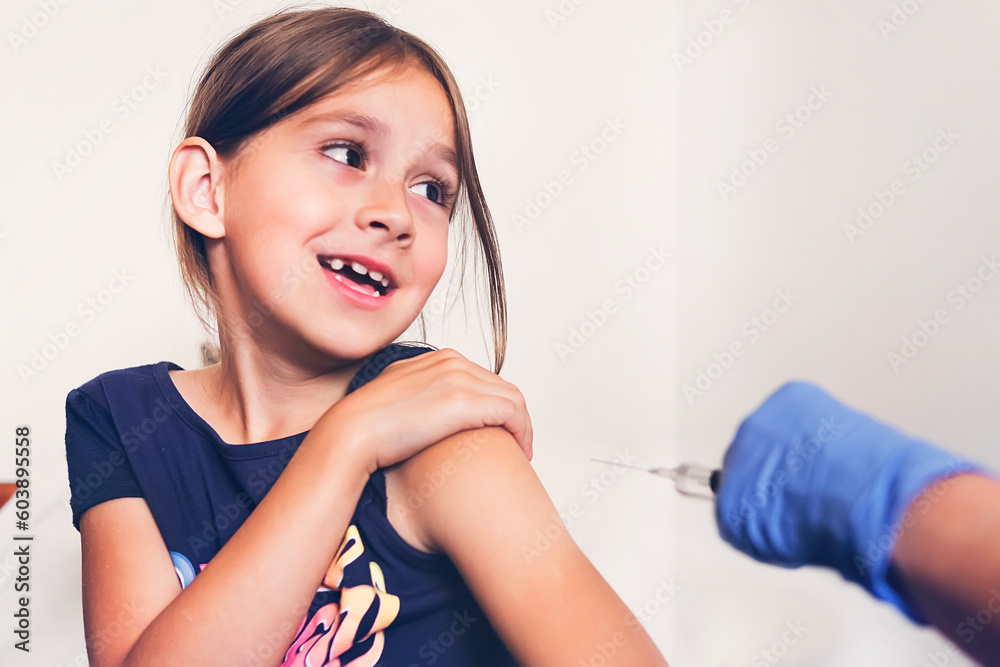 Naklejka premium Girl afraid of injections at the doctor's office. girl is experiencing pain and fear from the vaccination.