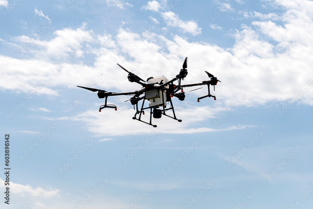 Agriculture drone flying in blue sky. Quadrocopter for pollination of plants. Modern technologies in agriculture. Agriculture drone flying in blue sky. Quadrocopter for pollination of plants. Modern technologies in agriculture.