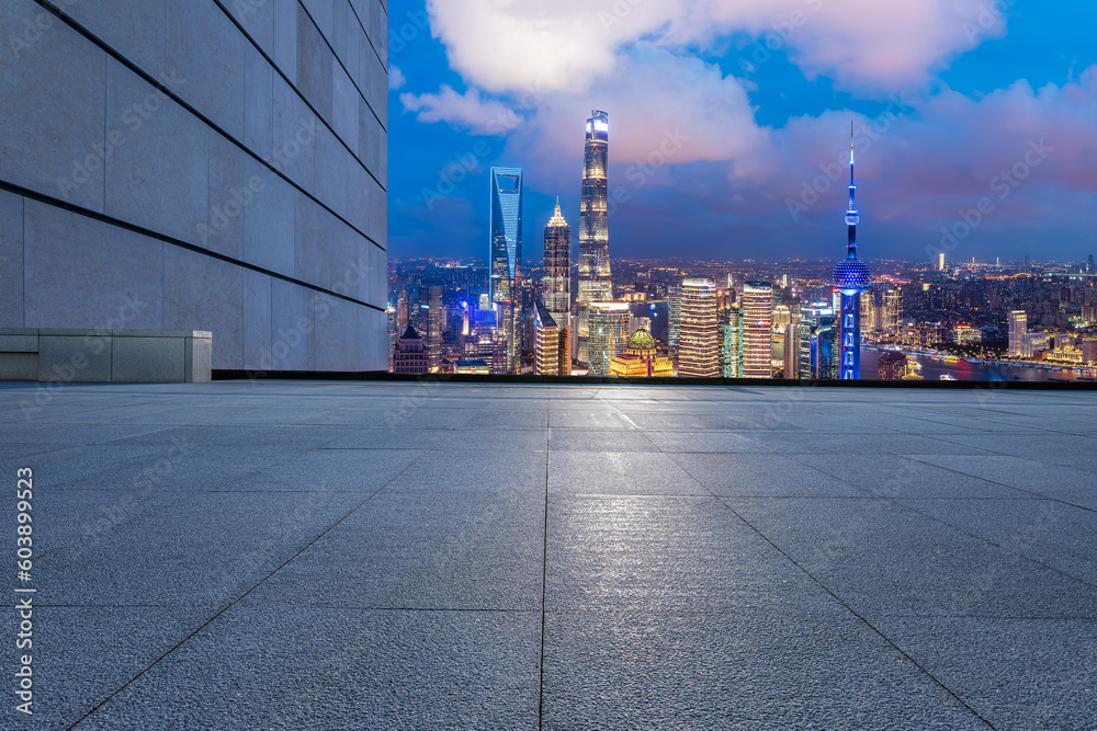 Empty square floor and city skyline with modern building at night in Shanghai, China.