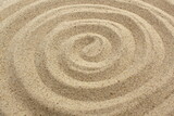 A spiral is drawn on the sand.