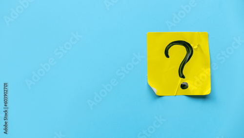 Q&A or questions and answers concept. Yellow sticker with handwritten question symbol on blue background.