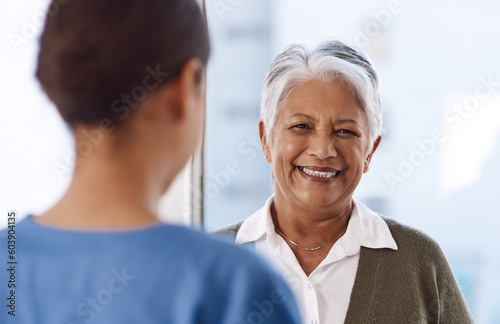 Healthcare, happy or nurse talking to an old woman about treatment in a nursing home facility clinic. Elderly face, smile or female medical worker speaking to a senior patient in a hospital visit