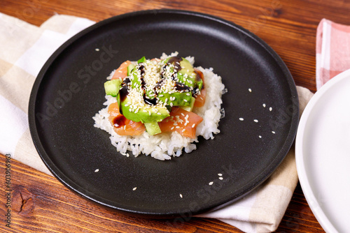 Sushi Waffle is crispy rice, made in a waffle maker, topped with shoyu salmon, crunchy cucumber, and avocado.