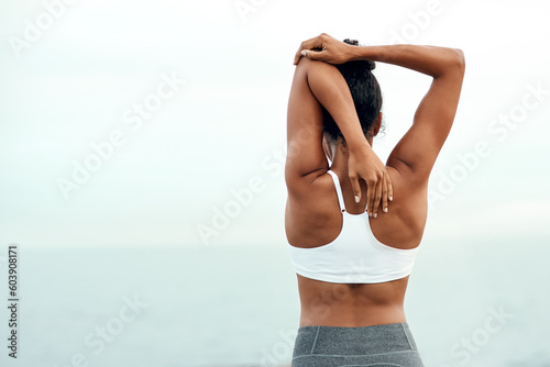 Woman, back stretching and outdoor for yoga, workout and training with mockup space. Wellness, nature and ocean with female person doing exercise for health and relax by the sea with stretch arms photo