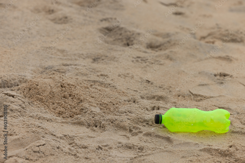 Used plastic water bottle washed up on the shore of a tropical beach, highlighting the worldwide crisis of plastic pollution on even the most remote islands Used plastic water bottle washed up on the shore of a tropical beach, highlighting the worldwide crisis of plastic pollution on even the most remote islands