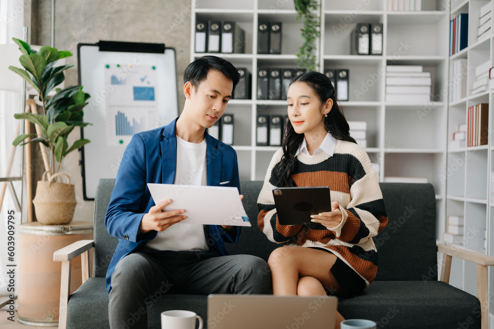 Two business workers talking on the smartphone and using laptop at the home office. Two business workers talking on the smartphone and using laptop at the home office.