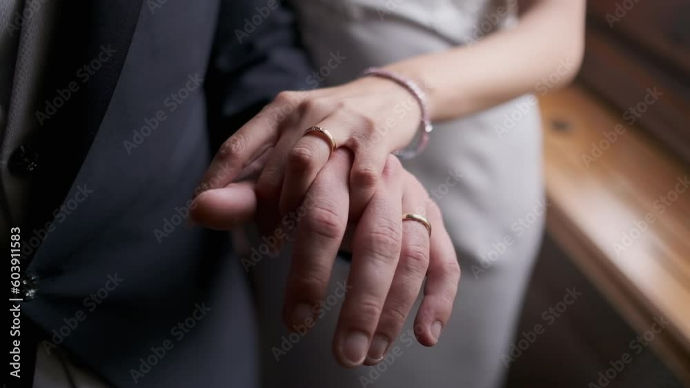 Closeup of wife and husband holding hands with rings on after wedding Closeup of wife and husband holding hands with rings on after wedding