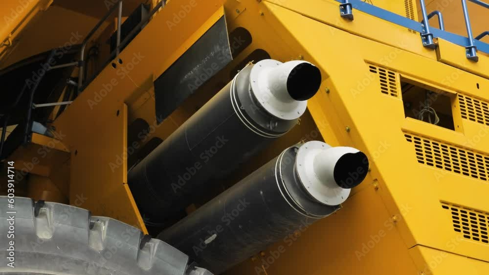 Close-up of the two exhaust pipes of the mining dump truck. The exhaust system of the world's largest mining truck. Panorama from bottom to top Close-up of the two exhaust pipes of the mining dump truck. The exhaust system of the world's largest mining truck. Panorama from bottom to top