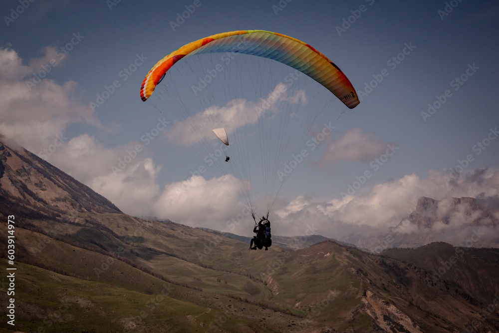 Paraglider flying over mountains in summer day Paraglider flying over mountains in summer day