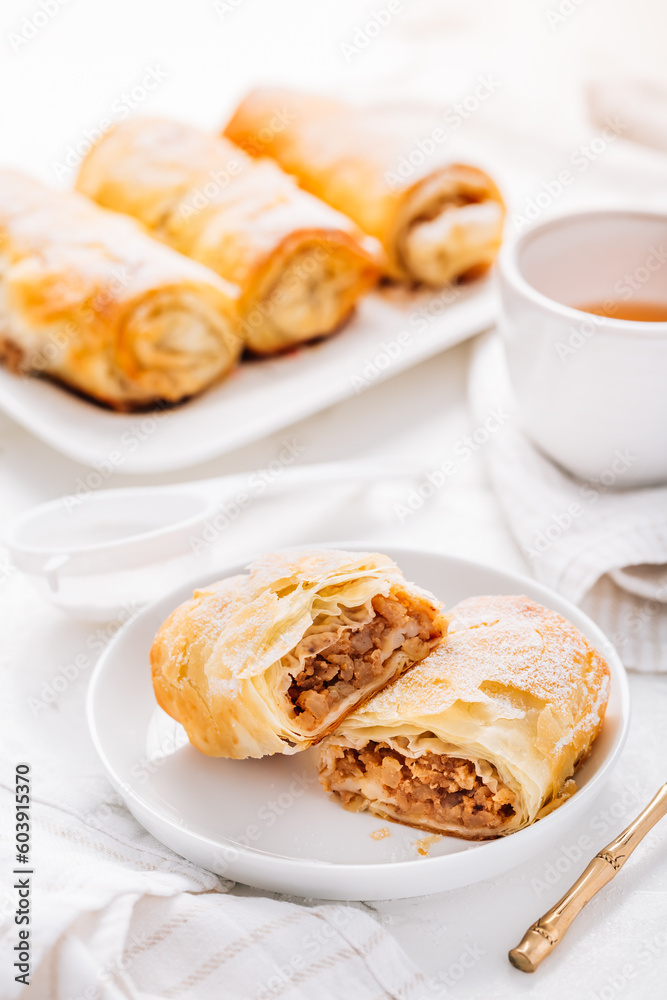 Homemade apple strudel with cinnamon, apple pie with cup of fruit tea Homemade apple strudel with cinnamon, apple pie with cup of fruit tea