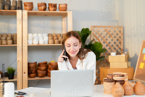 Caucasian seller girl happy calling to customer and confirm e-commerce order purchase on phone before packing product and deliver to their home