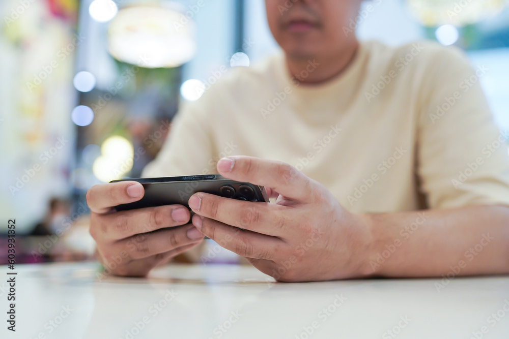 Man playing game on mobile phone. gamer boy playing video games holding Smartphone working mobile devices. cell telephone technology e-commerce concept Man playing game on mobile phone. gamer boy playing video games holding Smartphone working mobile devices. cell telephone technology e-commerce concept