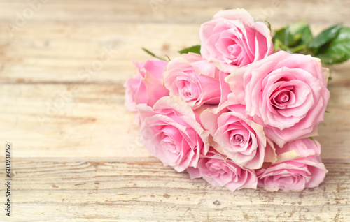 Pink roses on vintage old wooden table closed up flower buds and petals © igradesign