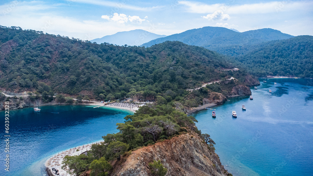 Aerial view of blue sea, rocky coast, trees and beach. Fethiye, Oludeniz, Turkey. Tropical landscape. Tourism background.