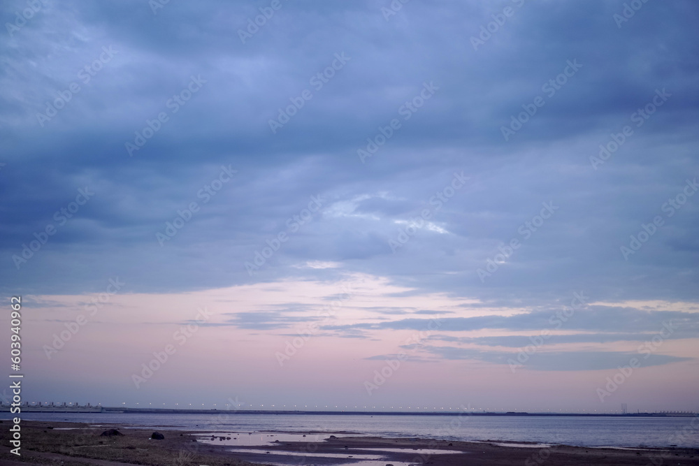 Obraz premium sunset over the sea. Beautiful cloudy evening sky. Dam bridge in the distance