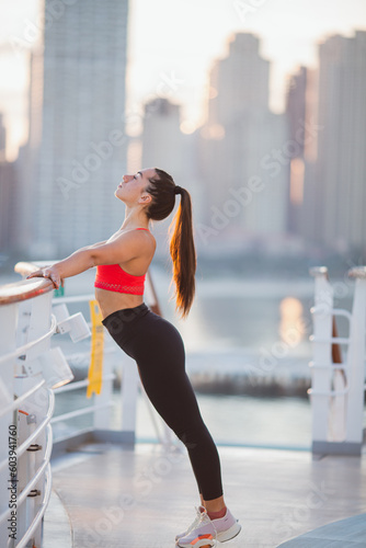 Athletic young woman stretching before running outdoors. Young sporty woman training. Woman Doing Workout Exercises On Street . Fit girl streaching before active fitness training