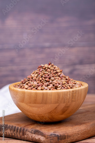 Sumac seeds. Dried sumac berries on wooden background. Spice concept