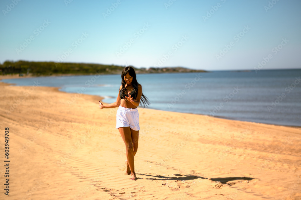 Happy joyful girl dancing on beach