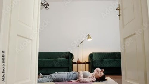 Tired young Caucasian woman wearing casual clothes lie on floor. Side view. Concept of dance training