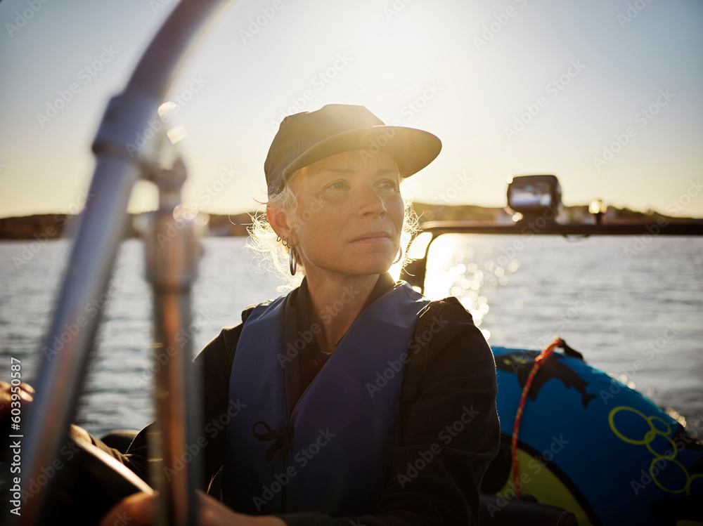 Woman driving boat on sea during sunset Woman driving boat on sea during sunset