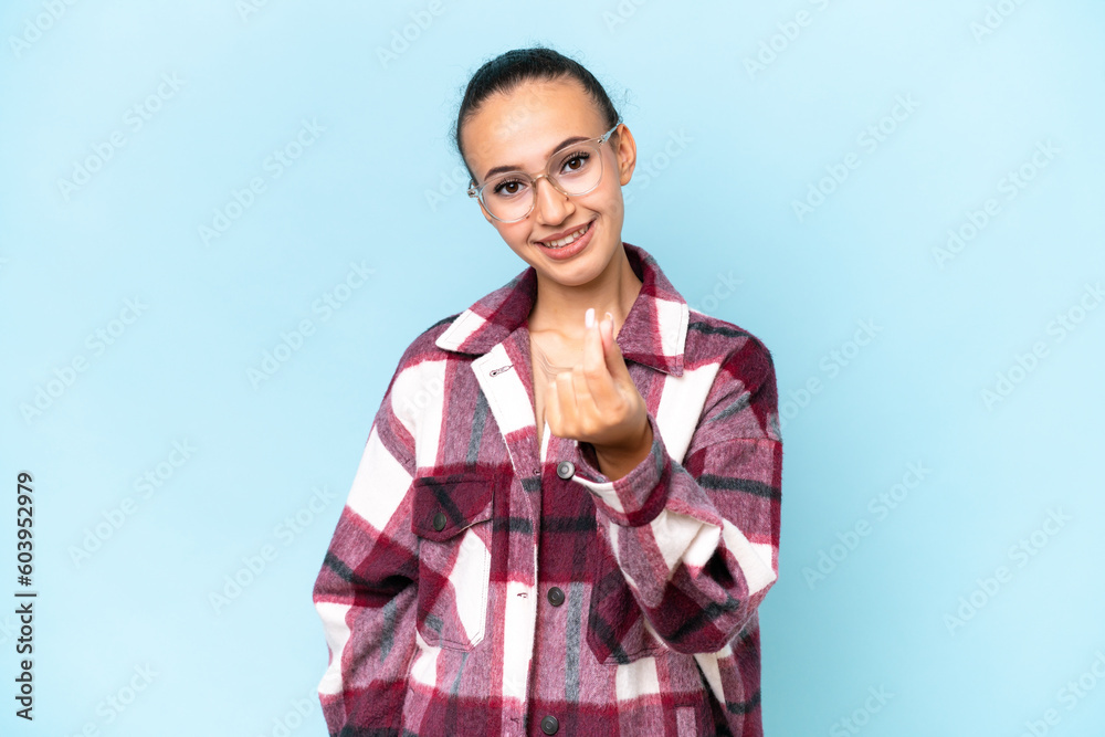 Young Arab woman isolated on blue background making money gesture Young Arab woman isolated on blue background making money gesture