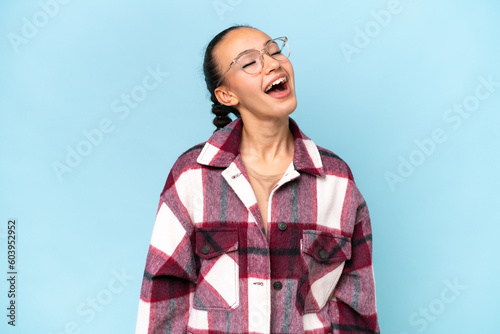 Young Arab woman isolated on blue background laughing