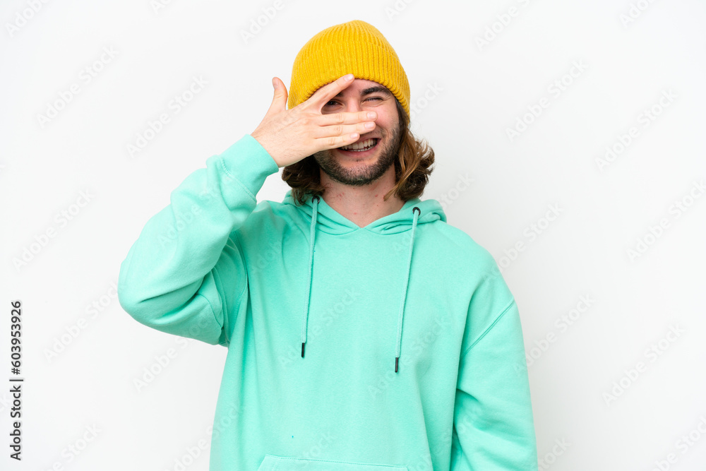Young handsome man isolated on white chroma background covering eyes by hands and smiling