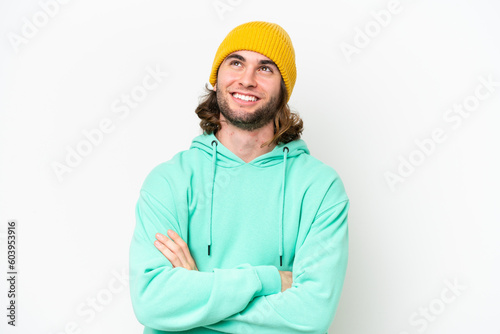 Young handsome man isolated on white chroma background looking up while smiling