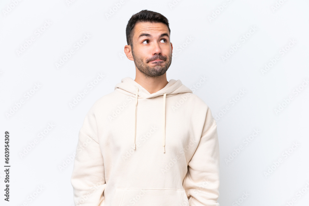 Young caucasian man isolated on white background having doubts while looking up Young caucasian man isolated on white background having doubts while looking up