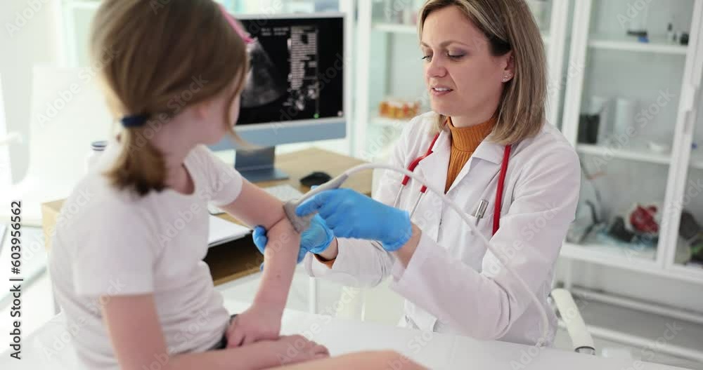 Child patient with orthopedic doctor in office. Ultrasound of elbow joint in children Child patient with orthopedic doctor in office. Ultrasound of elbow joint in children