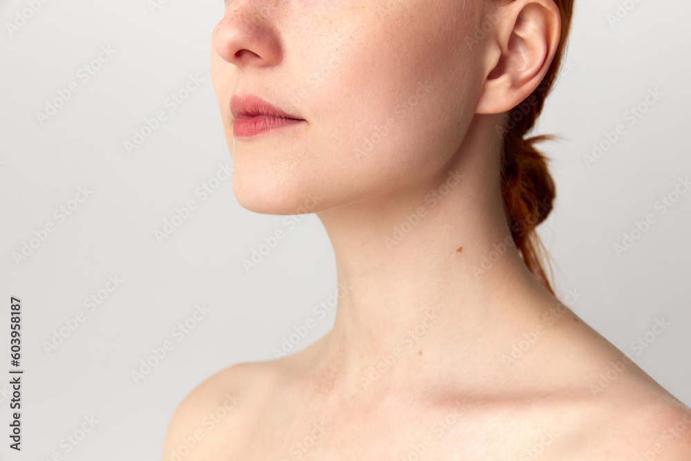 Portrait with young woman, girl with red hair standing over white studio background. Side view. Shot after plastic surgery. Chin correction Portrait with young woman, girl with red hair standing over white studio background. Side view. Shot after plastic surgery. Chin correction