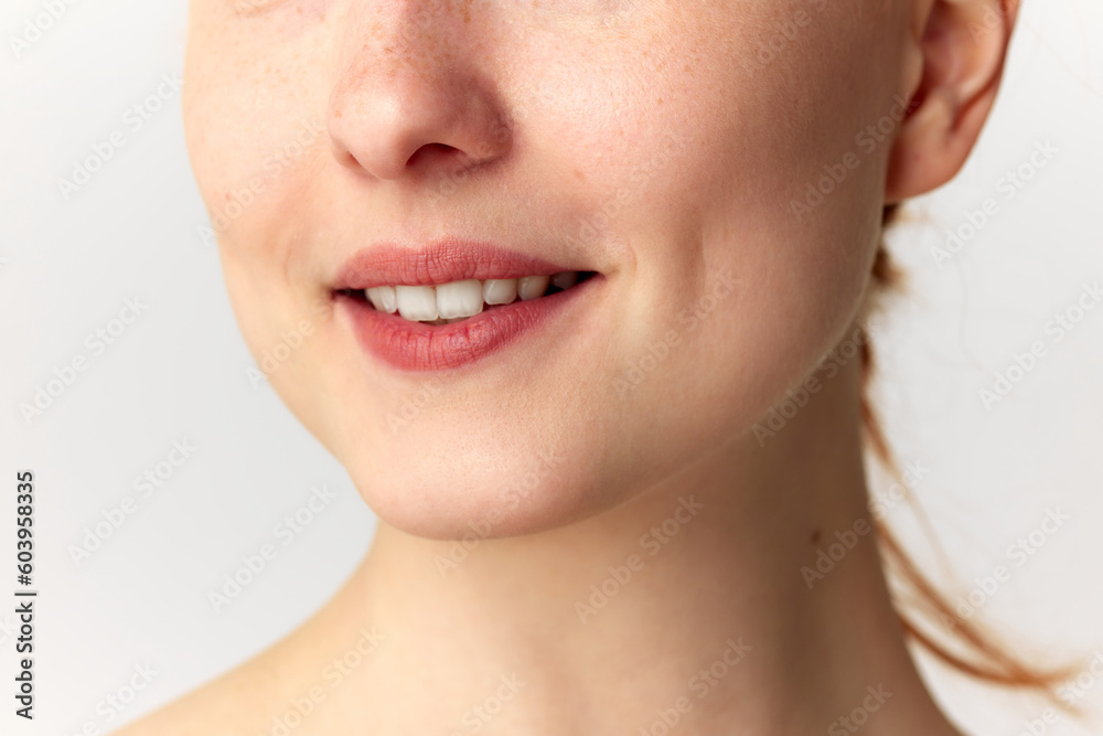Cropped portrait with lower face of young woman with snow-white smile. Model with well-kept, perfect skin. Teeth whitening