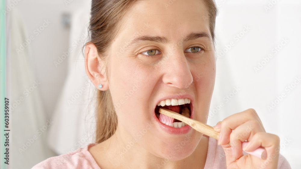 Portrait of brunette woman brushing her perfect white teeth with toothbrush Portrait of brunette woman brushing her perfect white teeth with toothbrush